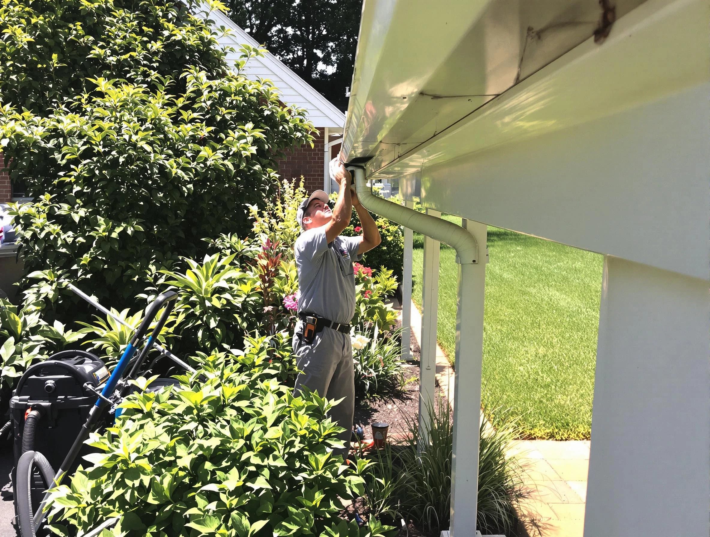 Technician flushing a blockage from a downspout in Eastlake, OH